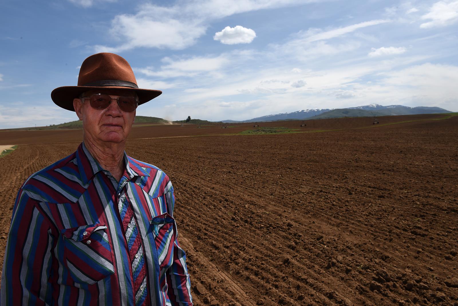 Don McFarland stands in a field at his Little Camas Ranch where a herd of elk damaged his organic grain crop. One of his organic potato fields, visible in the background, also suffered crop damage from the elk during the 2018 season.